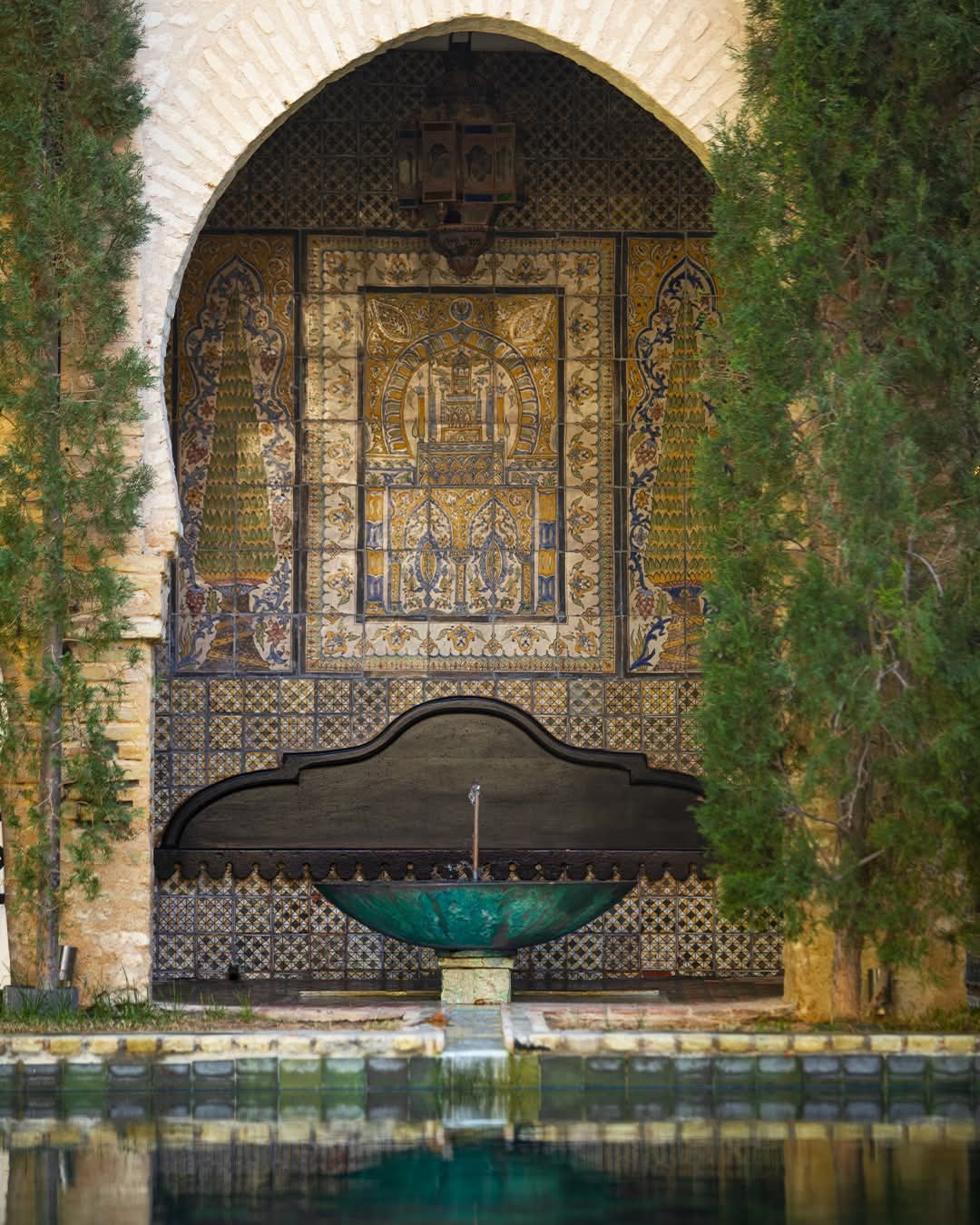 Fontaine de cuivre vert sous l'arche aux carreaux anciens